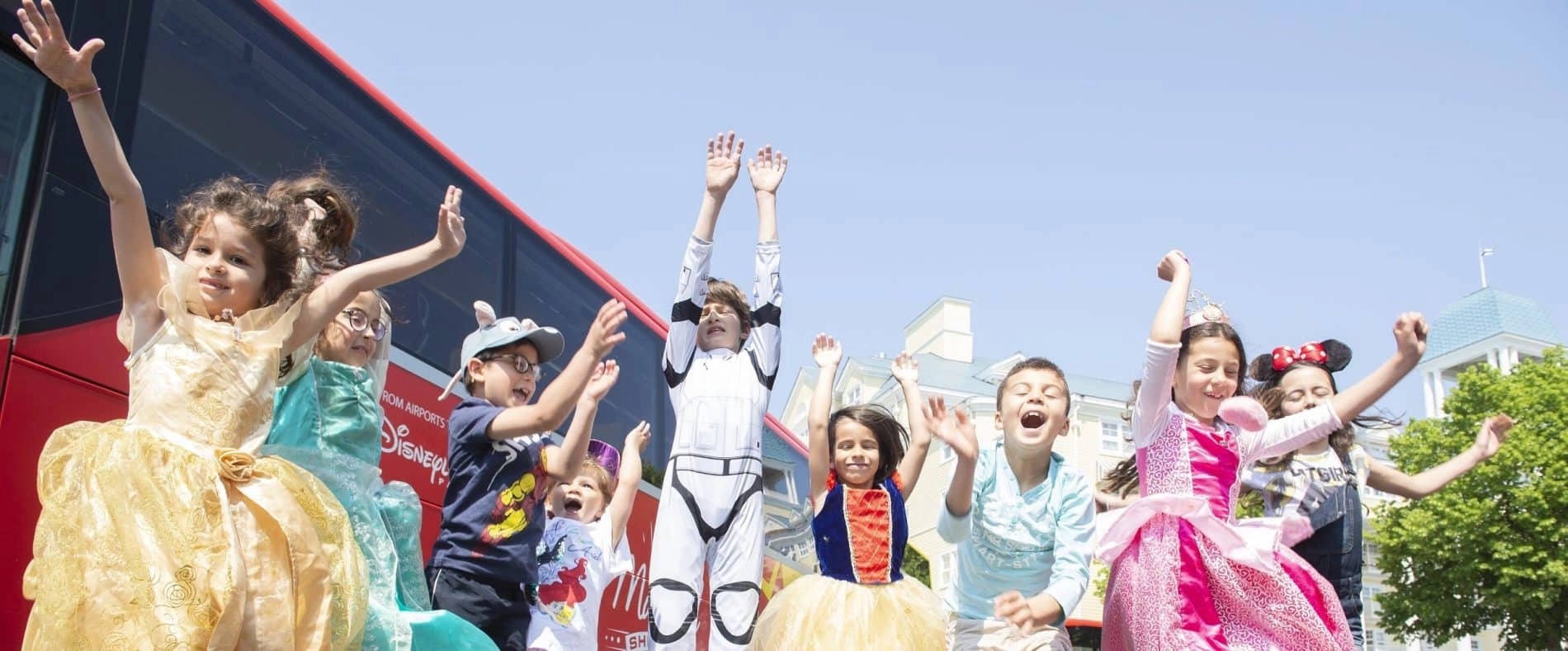 Kinder in Disney-Kostümen vor dem Magical Shuttle Bus